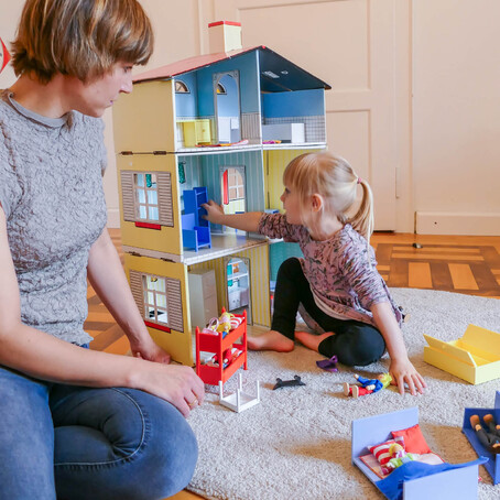 Kind spielt mit Puppenhaus – gezielte Sprachförderung bei Late Talkern.